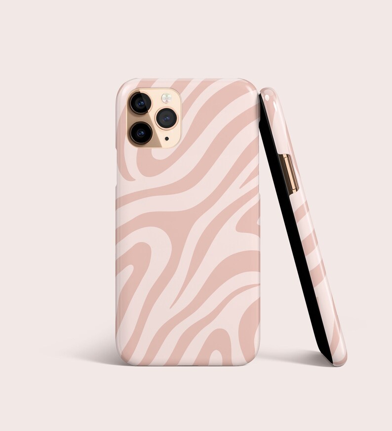 May include: Two phone cases with a pink and white zebra stripe pattern. One case is upright, displaying the camera lenses, while the other is leaning against it. The cases have a glossy finish and a black interior.