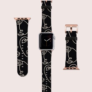 May include: Black Apple Watch band with a white abstract line design. The band is shown on a silver Apple Watch with a black face.