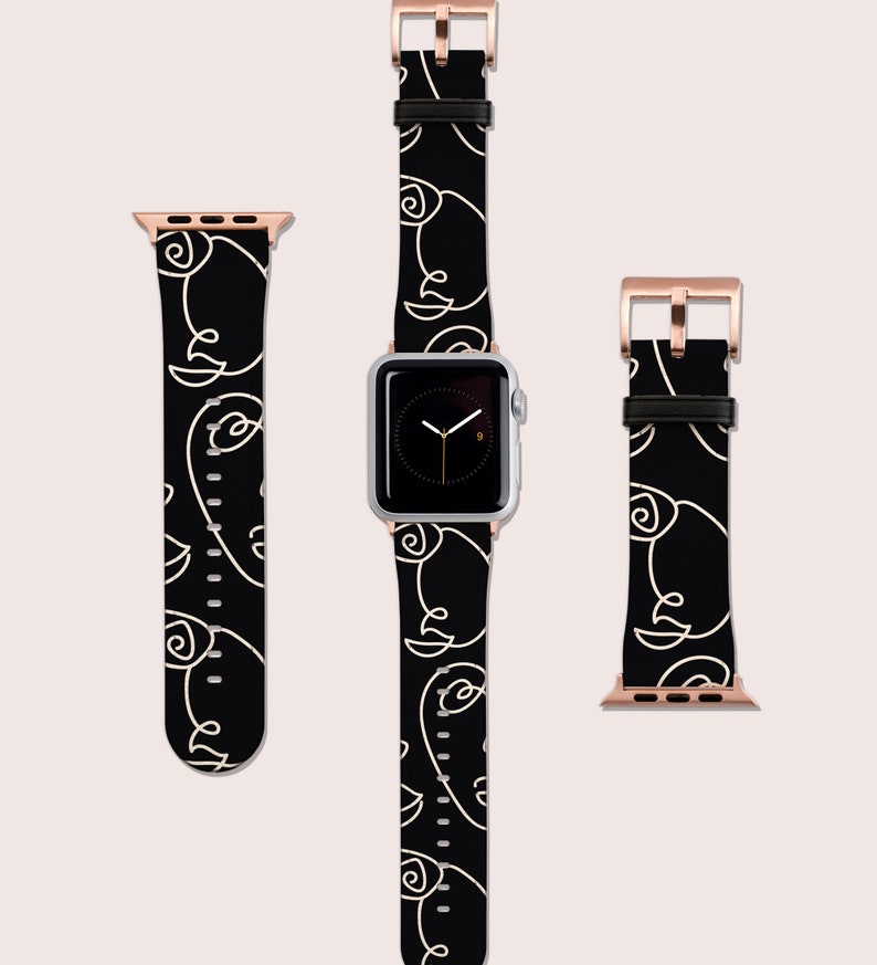 May include: Black Apple Watch band with a white abstract line design. The band is shown on a silver Apple Watch with a black face.
