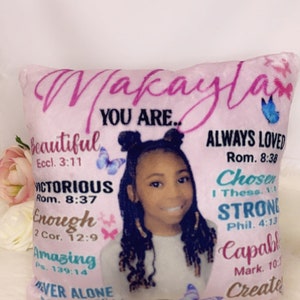 Puede incluir: Cojín de tiro rosa con la foto de una niña y citas inspiradoras y versículos bíblicos. El texto incluye "Makayla You Are... Beautiful, Victorious, Enough, Amazing, Never Alone, Always Loved, Chosen, Strong, Capable, Create".