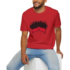 Puede incluir: Una camiseta roja con un gráfico negro de un cabello de una persona con el número "15" en una diadema roja.