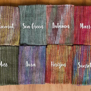 May include: Ten different striped fabric swatches with names written on each. The names are Coconut, Sea Green, Autumn, Mars, Moss, Aura, Horizon, Sunset, and two others that are too blurry to read.