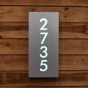 Peut inclure: Une plaque de numéro de maison en métal gris avec des chiffres blancs 2735.