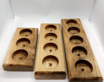 May include: Three wooden trays with circular cutouts. The trays are made of light brown wood with a natural finish. The trays are different sizes, with the largest tray having six cutouts, the middle tray having five cutouts, and the smallest tray having four cutouts.