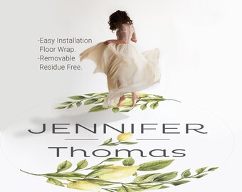 May include: A white oval floor sticker with a green leafy border and yellow lemons. The text "Jennifer Thomas" is printed in black on the sticker. A woman in a white dress is standing on the sticker.