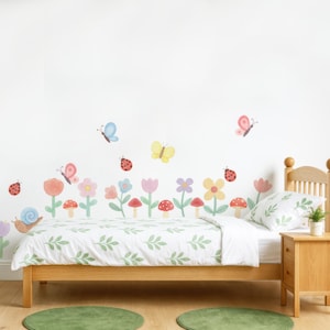 May include: A child's bedroom with a wooden bed frame, a white comforter with green leaf patterns, and a matching pillow. The wall features a colorful floral and insect mural with butterflies, ladybugs, flowers, and mushrooms. Two green circular rugs are on the floor.