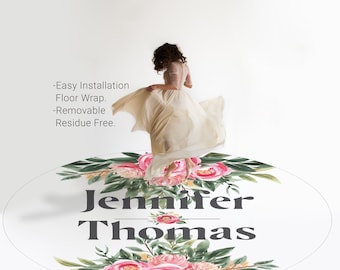 May include: A white oval floor mat with a floral design featuring pink and green watercolor flowers. The text "Jennifer Thomas" is printed in gray in the center of the mat.