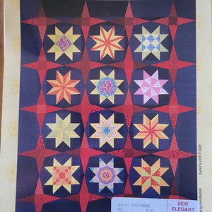 May include: A quilt pattern called "Shooting Stars - Pinwheel" featuring a pieced block of the month with 12 colorful star blocks. The pattern is $3.55 and is available from Sew Elegant in Port Huron, Michigan.