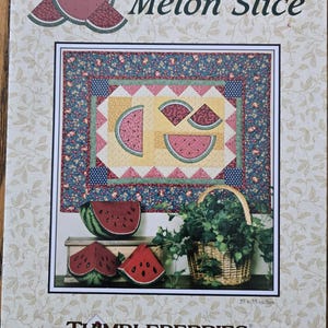 May include: A quilting pattern for a watermelon slice quilt. The pattern features a patchwork design with a variety of fabrics in shades of pink, red, green, blue, and yellow. The pattern is titled "Melon Slice" and is by Thimbleberries by Lynette Jensen. The finished quilt measures 27 x 35 inches.
