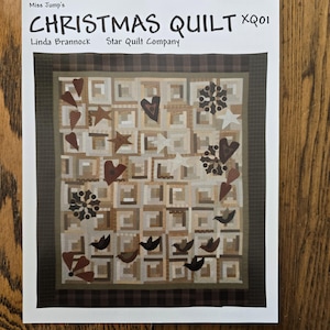 May include: A quilt pattern booklet titled "Christmas Quilt" by Linda Brannock, Star Quilt Company. The cover features a brown and white quilt with red hearts, white stars, and brown birds.