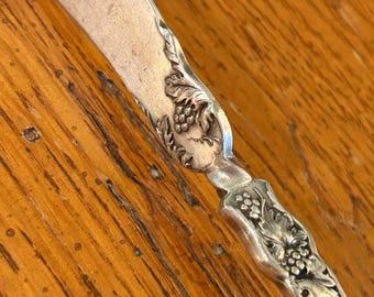 Cuchillo para queso Wm A Rogers A1 plateado con diseño de uvas, estilo vintage.