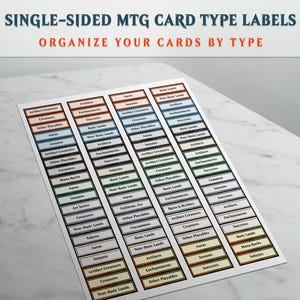 May include: A sheet of single-sided MTG card type labels with the text "SINGLE-SIDED MTG CARD TYPE LABELS ORGANIZE YOUR CARDS BY TYPE". The labels are rectangular with various colors and text such as "Artifact Creatures" and "Sorceries".