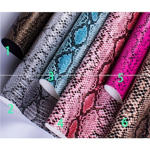 Op de afbeelding: Gerolde vellen imitatieleer met een slangenprint in diverse kleuren. Kleuren zijn metallic goud, zilver, blauwgroen, roze, fuchsia en bruin. Het materiaal heeft een getextureerde, geschubde uitstraling, ideaal voor knutselprojecten.