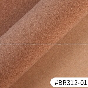 May include: A roll of textured, light brown cork fabric with a visible grain. The fabric is partially rolled, revealing a cross-section of the material. The lower right corner shows a section of plain, tan fabric. The text "#BR312-01" is in the lower right corner.