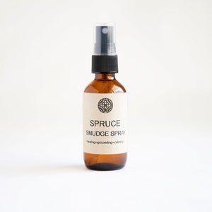 Pu&ograve; includere: Un flacone spray in vetro ambrato con erogatore in plastica nera ed etichetta in carta beige. L'etichetta presenta un'icona mandala circolare, il testo SPRUCE SMUDGE SPRAY e le parole healing~grounding~calming stampate in inchiostro nero.