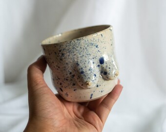 Ceramic stoneware coffee or tea cup in body form shape. Boob/breast/tit ceramic glazed glossy off white and blue paint splatter drops