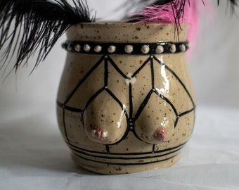 Stoneware ceramic boob vase with strappy harness lingerie in black on spotted clay with studded choker. Body tit/breast decorative vase