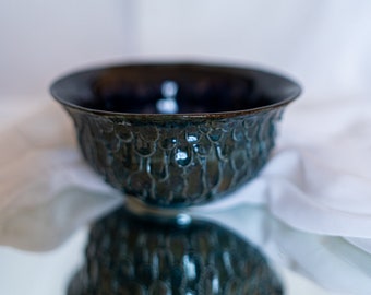 Dragon scales fantasy handmade ceramic ramen bowl with manually sculpted details in forest green blue glaze and a black deep blue effect.