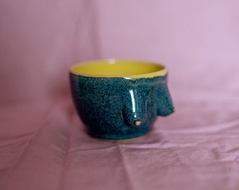 Ceramic stoneware small coffee or tea cup in body form shape. Boob/breast/tit ceramic glazed with glossy dark green-blue and yellow