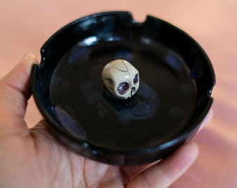 Gothic alternative handmade wheel thrown ceramic ashtray with a hand sculpted skull in the middle in nude colour. Black shiny witch decor