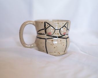 Stoneware ceramic boob mug with strappy harness lingerie in black on spotted clay with handle. Body tit/breast coffee/tea cup