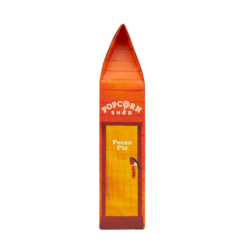 May include: A red and orange box with a yellow door and the text "Popcorn Shed" and "Pecan Pie". A small bird is perched on the door handle.