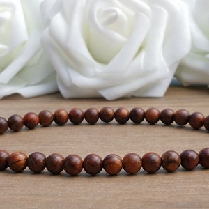 May include: A brown wooden beaded bracelet with round beads.