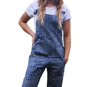 Op de afbeelding: Blauw-witte patroon tuinbroek met een wit t-shirt. De tuinbroek heeft een uniek ontwerp en heeft zakken. Het t-shirt heeft korte mouwen en een ronde hals. De tuinbroekriemen zijn op de schouders vastgebonden.