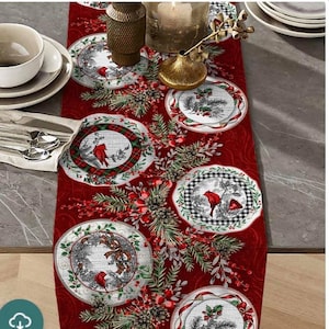 May include: Red table runner with a Christmas theme featuring a repeating pattern of stylized plates with cardinals, pine branches, berries, and plaid accents.
