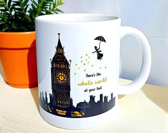 Taza con cita de Poppins – Cerámica. Imagen de Mary Poppins y el Big Ben en linóleo con la frase: “El mundo entero está a tus pies”.