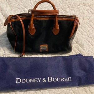 Preciosa cartera de piel negra de Dooney and Bourke. Rápida, de buen tamaño, no demasiado pesada para llevarla en un viaje largo, pero lo suficientemente grande para todo.