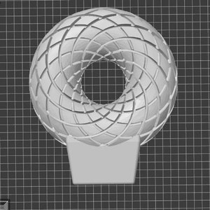 Op de afbeelding: Een wit, geometrisch, 3D-geprint object met een rond gat in het midden. Het object staat op een witte basis.