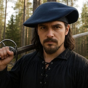 May include: A man wearing a dark blue beret and black shirt, holding a sword over his shoulder. The sword has a silver handle and blade. The background is a forest with tall trees.
