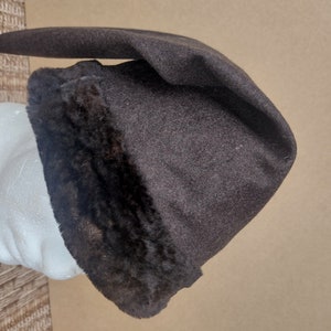 May include: A brown felt hat with a black fur trim. The hat has a pointed crown and a wide brim.