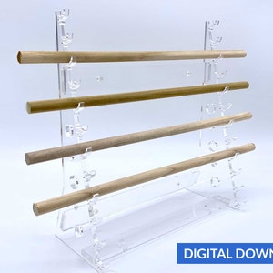 Pode incluir: Um suporte de acrílico transparente com quatro pinos de madeira. O suporte tem várias ranhuras para segurar os pinos.