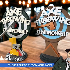 Puede incluir: Dos trofeos de madera para el campeonato de lanzamiento de hacha. El trofeo de la izquierda está pintado de negro y verde con un hacha blanca y el texto "Axe Throwing Championship". El trofeo de la derecha está pintado de marrón y azul con un hacha blanca y el texto "Axe Throwing Championship".