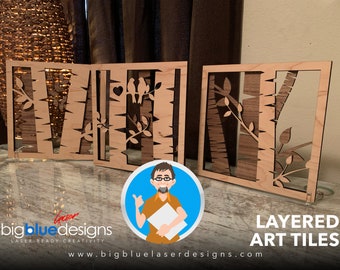May include: Three wooden layered art tiles with a nature theme. Each tile features a design of trees and birds. The tiles are arranged in a row on a table. The text "LAYERED ART TILES" is visible at the bottom of the image.