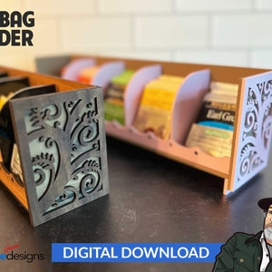 Könnte beinhalten: Digitaler Download eines Teebeutelhalters. Der Halter ist aus Holz und hat ein dekoratives Muster auf der Vorderseite. Der Halter ist mit Teebeuteln gefüllt.