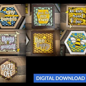 May include: A collection of layered wooden art pieces with bee-themed designs. The pieces feature phrases like "Stay Bumble," "Bee Happy," and "Honey Yourself." The color palette includes yellow, blue, and brown, with honeycomb patterns.