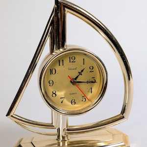 Reloj de plástico dorado con forma de velero vintage
