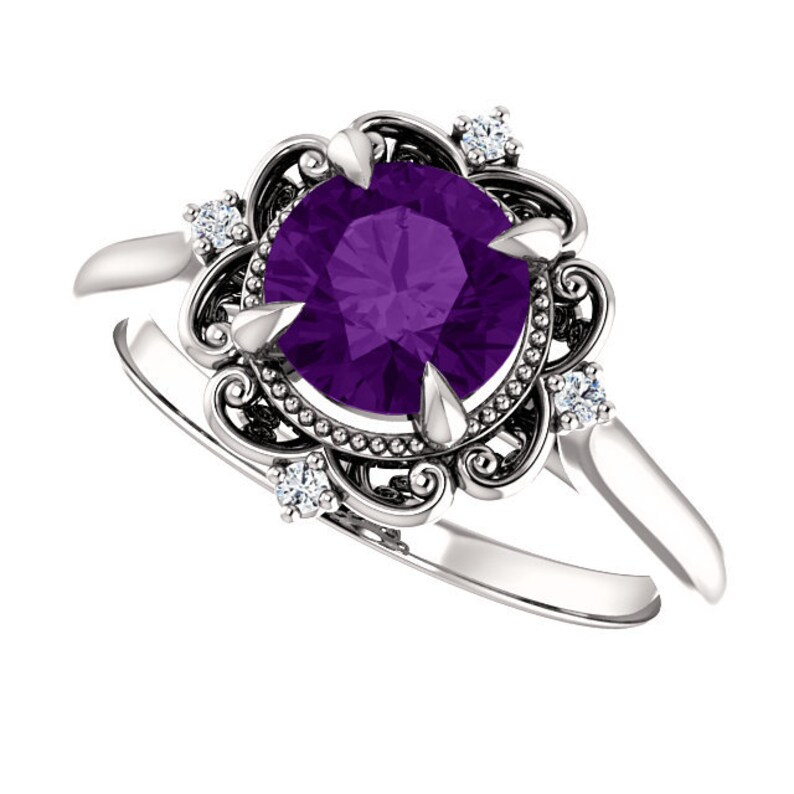 May include: A silver ring featuring a large, round, purple amethyst gemstone set within a delicate, ornate filigree design.  Four smaller, round, white diamonds embellish the filigree.