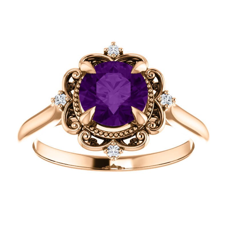 May include: A rose gold ring featuring a large, round, purple amethyst gemstone set in a filigree design with smaller diamonds around the centre stone.