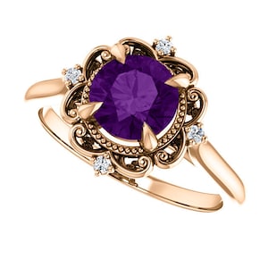May include: A rose gold ring featuring a large, round, purple amethyst gemstone set in a filigree design. The ring is accented with four smaller, round, white diamonds.