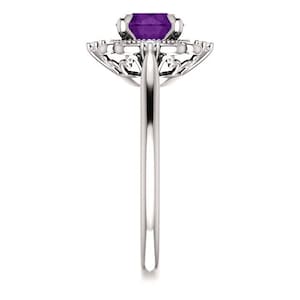 May include: A silver ring featuring a large, purple amethyst gemstone encircled by smaller diamonds. The ring boasts a delicate, ornate design.