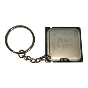 Può includere: Un portachiavi color argento con un anello e una catena di metallo attaccati a un processore per computer. Il processore è quadrato con un bordo verde e riporta la scritta "INTEL CORE 2 DUO".