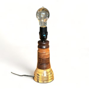 May include: A wooden table lamp with a brown and yellow base and a clear glass light bulb.