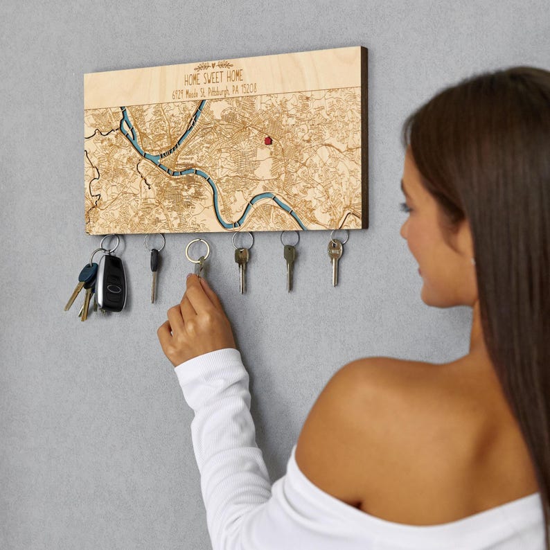 May include: A wooden key holder with a map of Pittsburgh, Pennsylvania, and the text "Home Sweet Home 6329 Meade St. Pittsburgh, PA 15208". The key holder has five hooks for hanging keys.