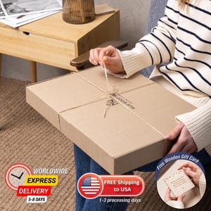 May include: A rectangular cardboard box tied with twine. The box is being held by a person wearing a striped sweater. The box has the text "MUR WOOD HOME" printed on it. A free wooden gift card is included.