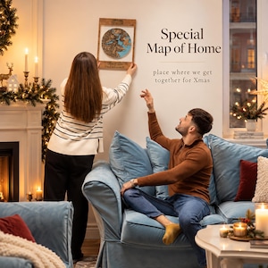 May include: A rectangular wooden wall frame containing a circular, multi-layered topographic map with blue water and brown land details. The frame features the text "Special Map of Home" and "place where we get together for Xmas" printed nearby.