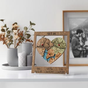 Custom locations framed wood wall art—personalized puzzle map heart with couple names and anniversary dates.